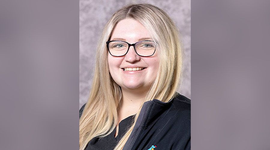 Portrait of a smiling woman with glasses and long blonde hair.